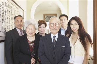 Multi-generational Asian family smiling indoors