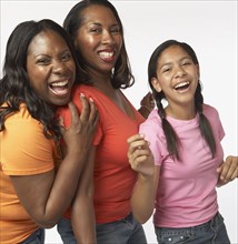 African mother and daughters laughing and hugging