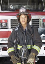 African female firefighter in front of fire truck