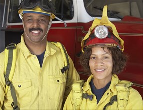Two African firefighters next to fire truck
