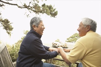 Senior Asian couple talking and laughing outdoors
