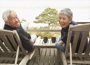 Senior Asian couple smiling outdoors