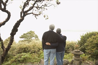 Senior couple standing arm in arm outdoors