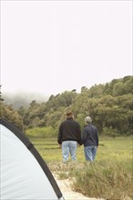 Senior couple holding hands next to tent