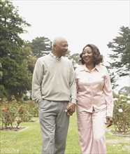 Senior African couple holding hands and walking outdoors