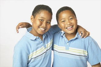 Young African twin brothers hugging and smiling