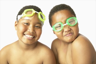 Young African twin brothers wearing swimming goggles