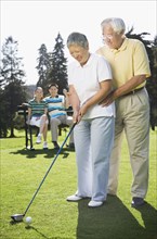 Senior Asian couple playing golf