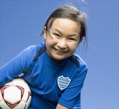 Mixed Race girl holding soccer ball