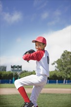 Mixed race boy pitching in baseball game