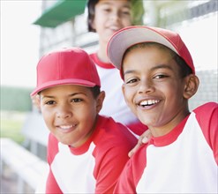 Multi-ethnic boys in baseball uniforms smiling