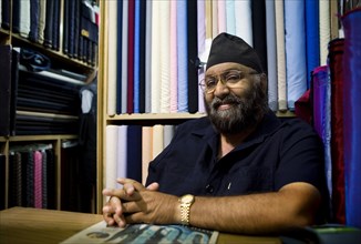 Indian business owner sitting in fabric store