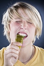Caucasian boy eating pickle