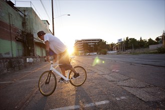 Man doing stunts on bicycle on city street