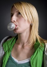 Caucasian woman blowing bubble with bubble gum