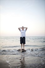 Caucasian woman standing on rock in ocean