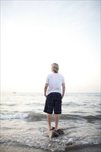 Caucasian woman standing on rock in ocean