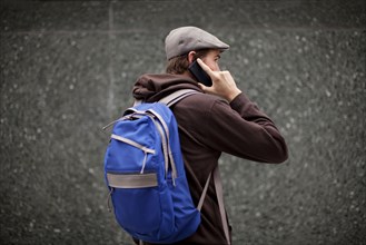 Caucasian man in backpack talking on cell phone
