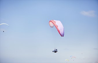 Person paragliding against blue sky