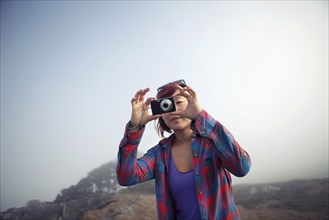 Korean woman taking photograph with digital camera