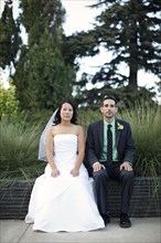 Bride and groom sitting outdoors