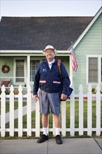 Caucasian mailman standing on sidewalk