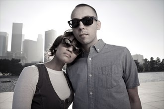 Couple wearing sunglasses on urban waterfront