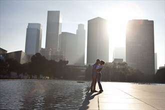 Couple kissing by urban waterfront