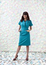 Mixed race businesswoman by wall of sticky notes