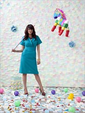 Mixed race businesswoman with pinata in office