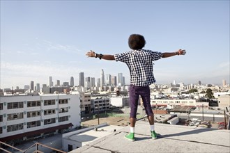 African American man overlooking cityscape from urban rooftop