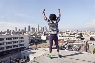 African American man overlooking cityscape from urban rooftop