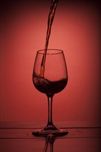 Red wine pouring into wine glass