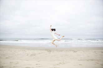 Woman jumping for joy on beach