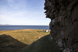 Rocky cliff over rural field and seascape