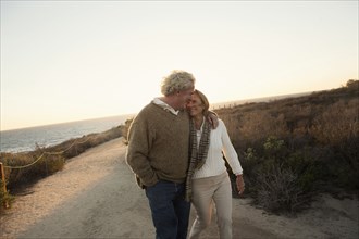 Older Caucasian couple walking on dirt path