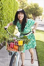 Woman carrying produce in bicycle basket