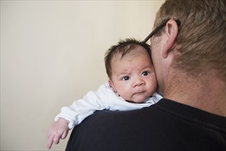 Close up of father holding mixed race baby