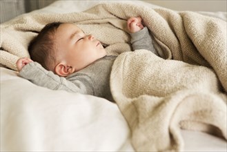 Mixed race baby sleeping in bed