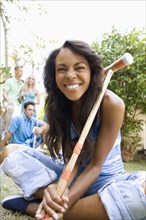 Smiling woman holding croquet mallet in backyard