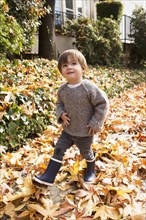 Mixed Race boy walking in autumn leaves