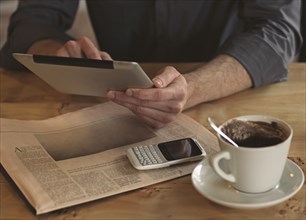 Man using digital tablet with cup of coffee