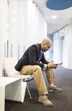 Caucasian businessman using digital tablet in office lobby