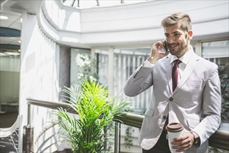 Caucasian businessman talking on cell phone on office balcony