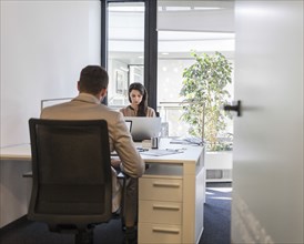 Caucasian business people working at desks in office