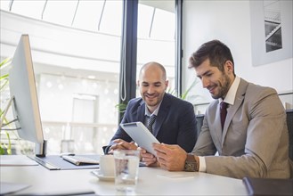 Caucasian businessmen using digital tablet in office