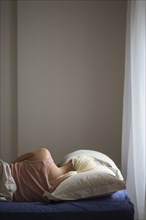 Rear view of woman sleeping in bed