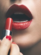 Close up of woman applying red lipstick