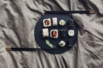 Close up of sushi platter with chopsticks in bed