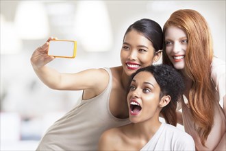Smiling women taking cell phone selfie